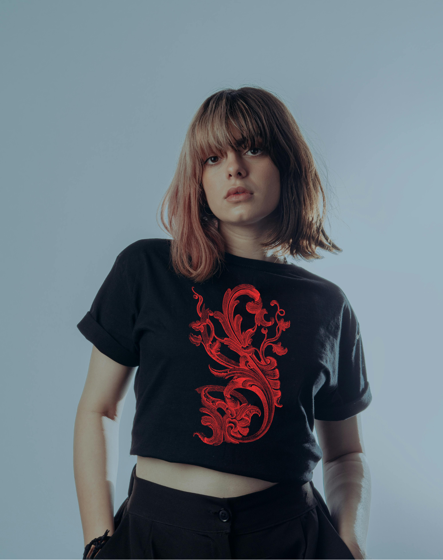 Person wearing a black t-shirt with red graphic design against a plain background